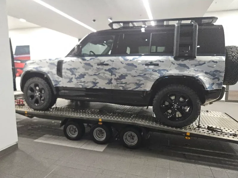 Land Rover Defender auf einem Fahrzeugtransportanhänger