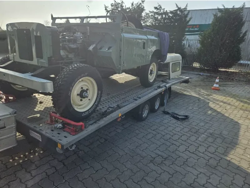 Historischer Geländewagen auf einem Fahrzeugtransportanhänger