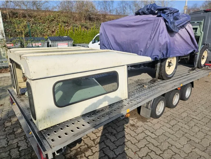Teile eines historischen Fahrzeugs auf einem Transportanhänger